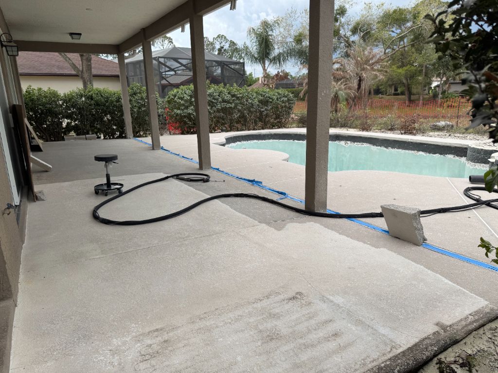 Wide view of pool deck sandblasting project — full patio and pool surround showing clean concrete result
