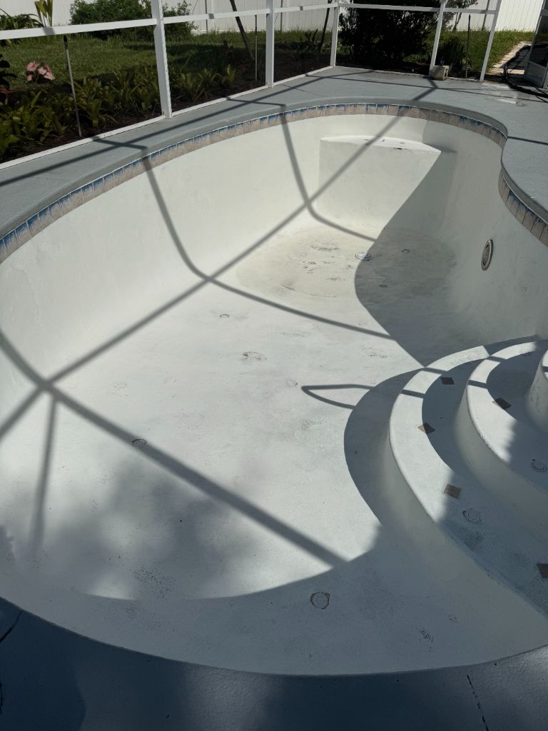 Pool shell before blasting — old paint still covering the surface